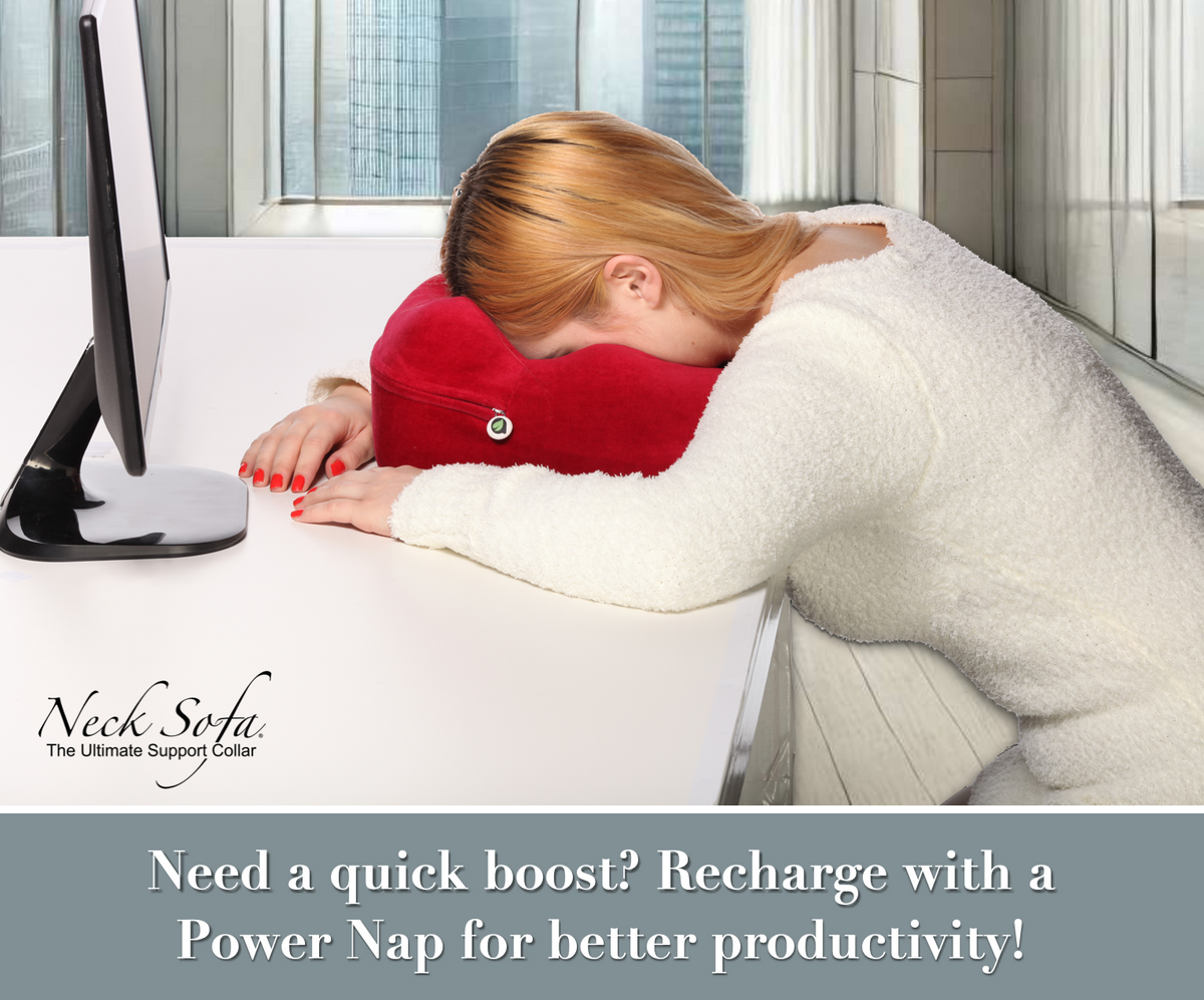 Bright modern office room with large windows, with a city view outside. A woman at her desk taking a power nap with a Burgundy Neck Sofa Pillow.