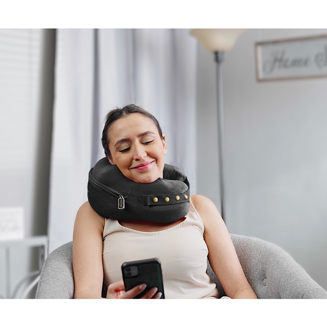 person texting while wearing comfortable neck supporting pillows for sleeping travel spine support - black